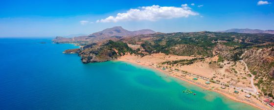 Aerial birds eye view drone photo Tsambika beach near Kolympia on Rhodes island, Dodecanese, Greece. Sunny panorama with sand beach and clear blue water. Famous tourist destination in South Europe